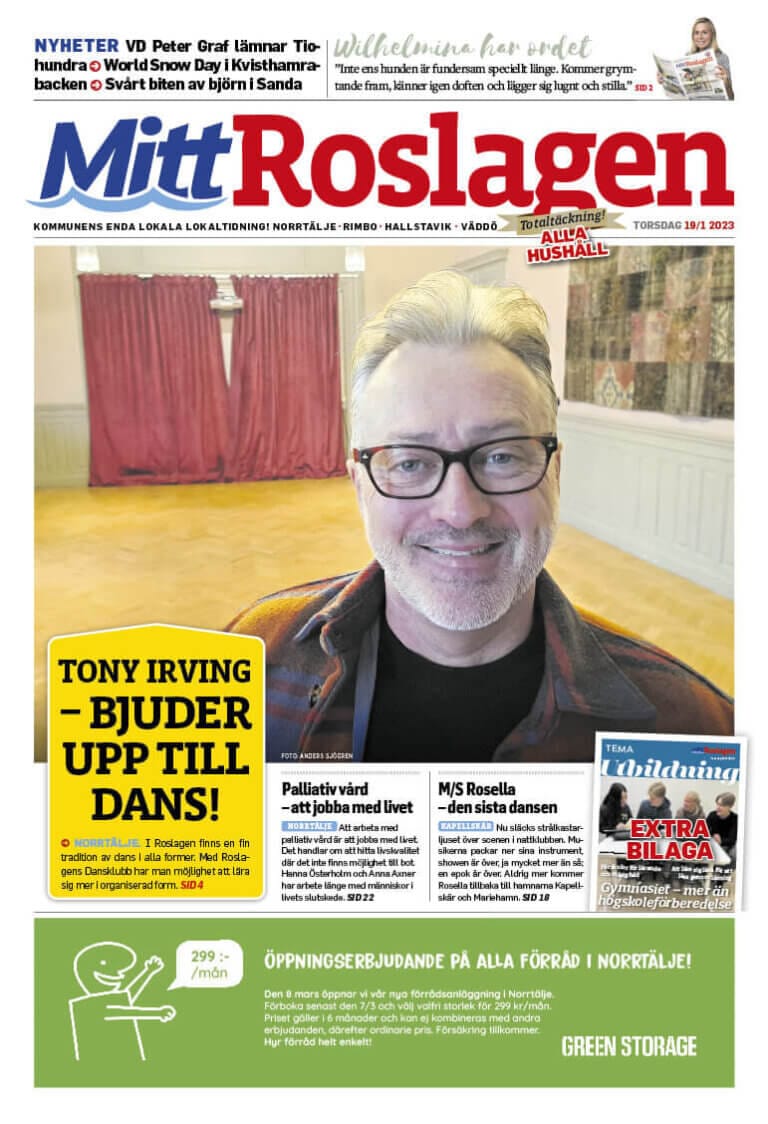 Framsidan av "Mitt Roslagen" tidning från TORSDAG, JAN 2023, visar en person med glasögon och halsduk. Rubrikerna innehåller en dansinbjudan av Tony Irving tillsammans med artiklar om jobbmöjligheter och lokala nyheter.