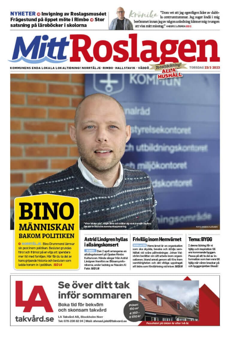 Mitt Roslagens omslag visar en man i blå tröja framträdande, inramad av rubriker om lokalpolitik, bibliotekspolitik och byggande. Automatiskt utkast framhävs i den livfulla layouten. Annonser, inklusive en för försäkring, kantar längst ner.