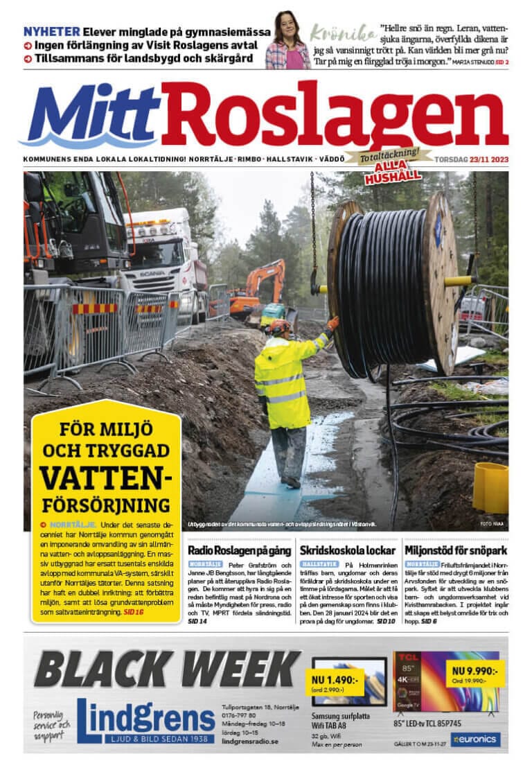 En byggnadsarbetare i en synlig jacka går längs en väg med stora kablar till höger medan en kran arbetar till vänster. Tidningshuvudet lyder "Mitt Roslagen TORSDAG, 23 NOV 2023", med olika rubriker och texter som täcker sidan.